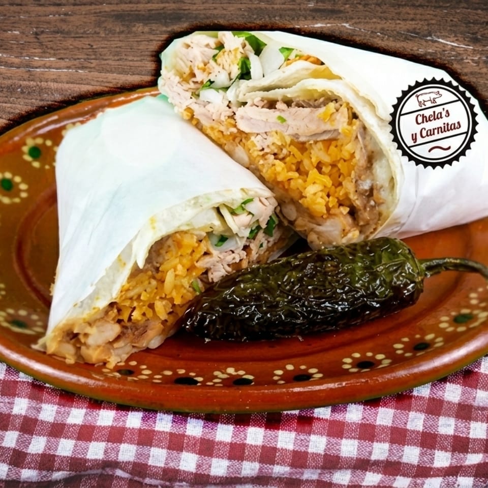 Two Chela's y Carnitas burritos with rice, meat, and cilantro, served with a roasted jalapeño.